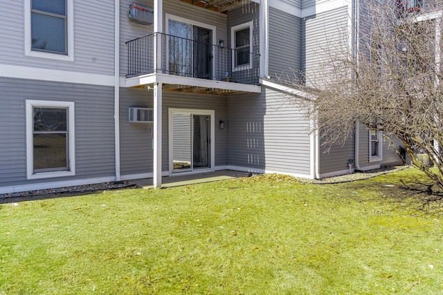 rear view of property with a lawn and a balcony