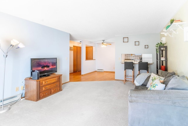 carpeted living area with baseboard heating, a baseboard heating unit, and ceiling fan