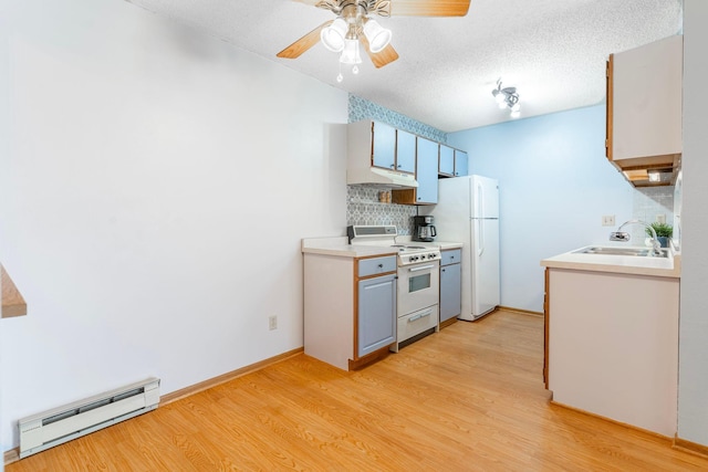 kitchen with white appliances, a baseboard radiator, a sink, decorative backsplash, and under cabinet range hood