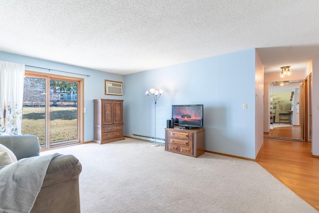 living area featuring an AC wall unit, a textured ceiling, carpet flooring, a baseboard radiator, and baseboards