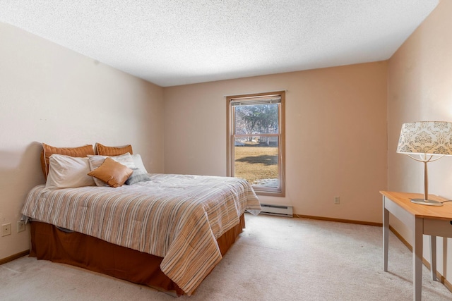 bedroom featuring a baseboard heating unit, baseboards, a textured ceiling, and light carpet