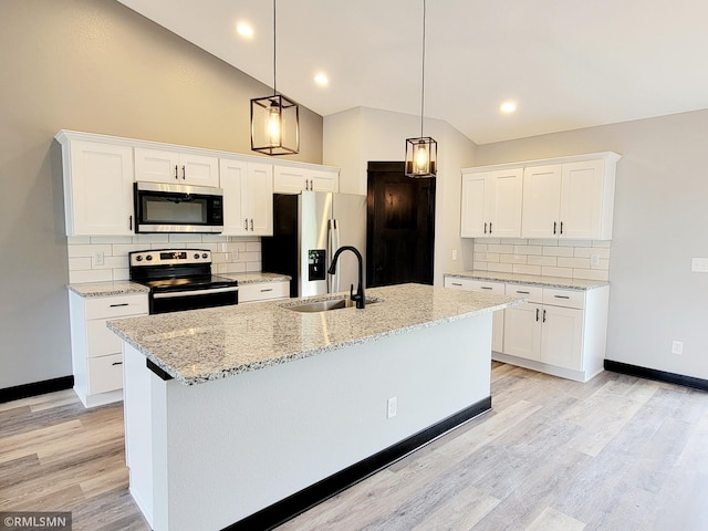 kitchen featuring white cabinetry, vaulted ceiling, hanging light fixtures, a center island with sink, and stainless steel appliances