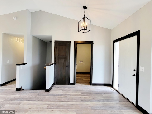 interior space with vaulted ceiling, a notable chandelier, and light hardwood / wood-style floors