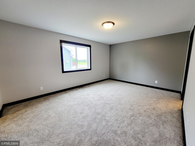 carpeted empty room with a textured ceiling