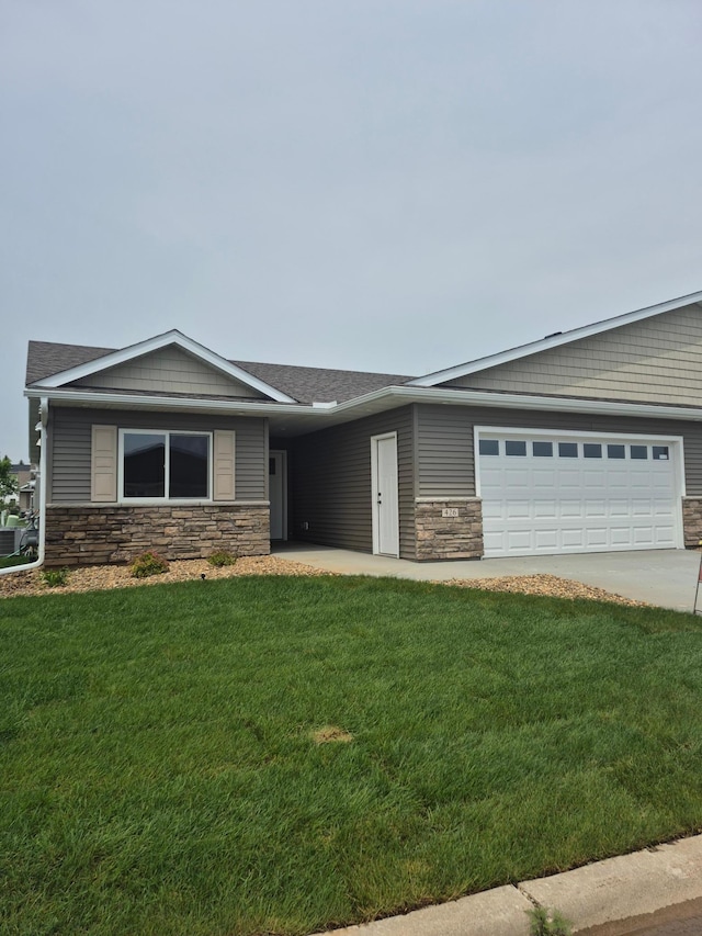 426 Fawn Run, Kenyon, MN 55946 - view of front of home featuring stone siding, a front lawn, an attached garage, and driveway