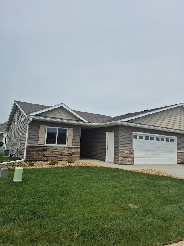 426 Fawn Run, Kenyon, MN 55946 - view of front facade featuring stone siding, a front yard, and an attached garage