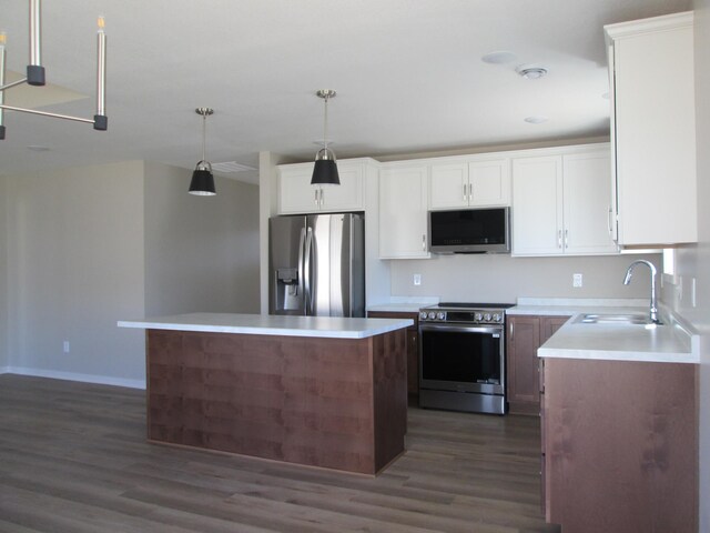 426 Fawn Run, Kenyon, MN 55946 - kitchen with stainless steel appliances, dark wood finished floors, a kitchen island, white cabinets, and light countertops