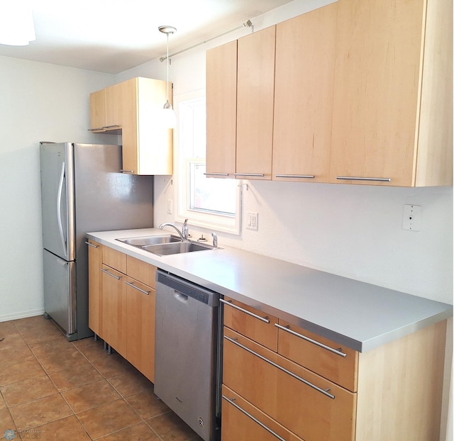 kitchen with stainless steel appliances, a sink, hanging light fixtures, light countertops, and light brown cabinetry