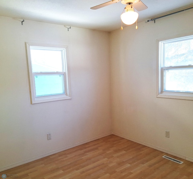 unfurnished room featuring baseboards, visible vents, and light wood-style floors