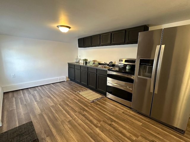 kitchen featuring dark wood finished floors, a baseboard radiator, appliances with stainless steel finishes, light countertops, and a sink