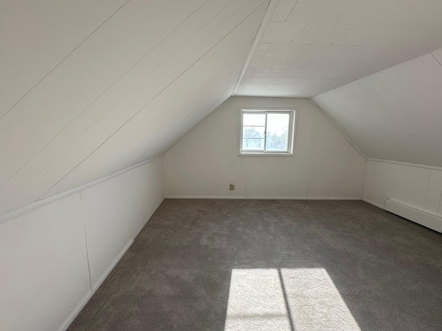 bonus room featuring a baseboard radiator, vaulted ceiling, and dark colored carpet