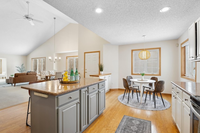 11767 36th Cir NE, Saint Michael, MN 55376 - kitchen with gray cabinetry, a kitchen island, ceiling fan, a kitchen breakfast bar, and a chandelier