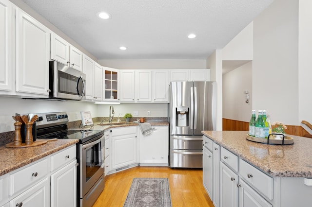 11767 36th Cir NE, Saint Michael, MN 55376 - kitchen featuring appliances with stainless steel finishes, white cabinetry, light wood-style floors, a sink, and recessed lighting
