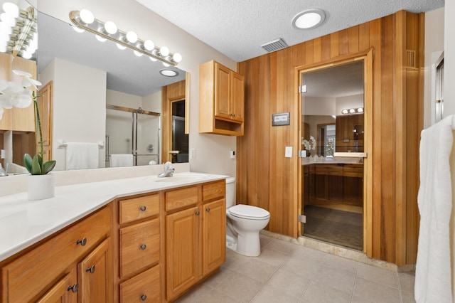 11767 36th Cir NE, Saint Michael, MN 55376 - bathroom featuring a stall shower, vanity, toilet, tile patterned flooring, and wood walls