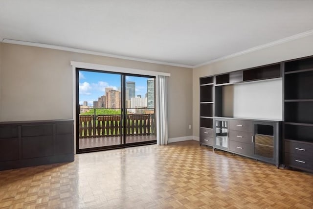 unfurnished living room featuring baseboards, ornamental molding, and a city view