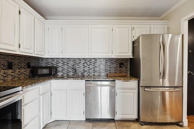 kitchen with white cabinets, tasteful backsplash, dark stone counters, and stainless steel appliances