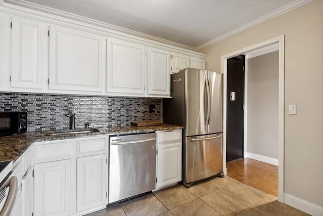 kitchen with stainless steel appliances, tasteful backsplash, ornamental molding, white cabinets, and a sink