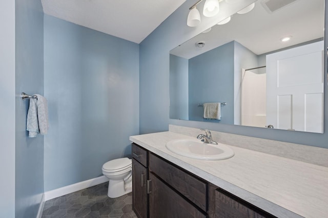 bathroom with a shower, vanity, and toilet