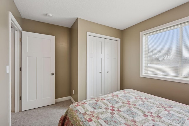 carpeted bedroom featuring a closet and a textured ceiling