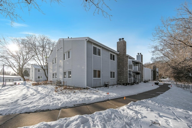 snow covered property with a chimney