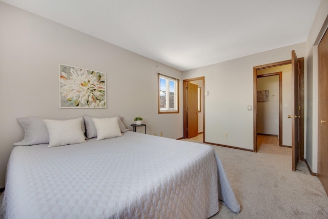 bedroom with light carpet and baseboards