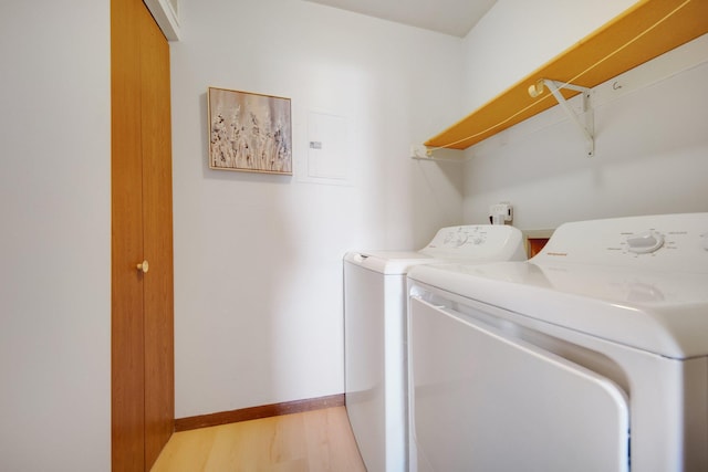 laundry room with laundry area, washing machine and dryer, baseboards, and light wood-style floors