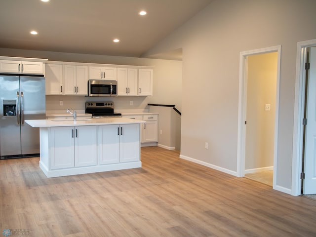 kitchen with white cabinetry, appliances with stainless steel finishes, and an island with sink