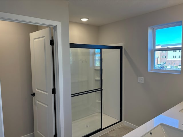 bathroom with baseboards and a shower stall