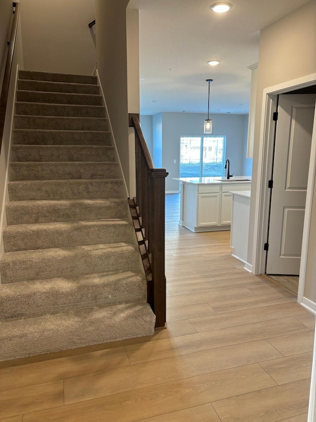 stairs with baseboards, recessed lighting, and wood finished floors
