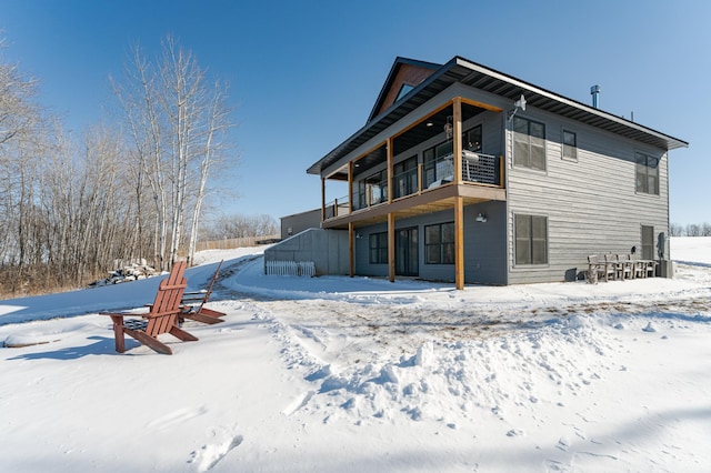 snow covered property with a balcony