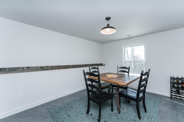 dining space featuring baseboards and concrete flooring