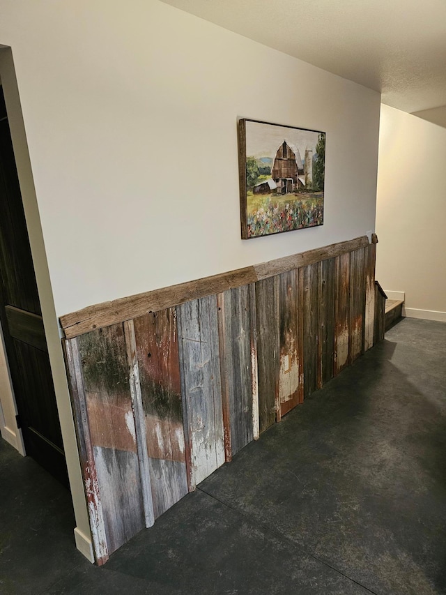 staircase featuring baseboards and concrete flooring