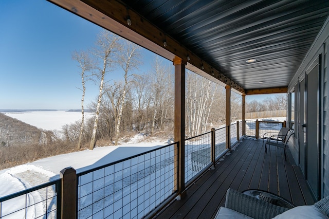 snow covered deck featuring a water view