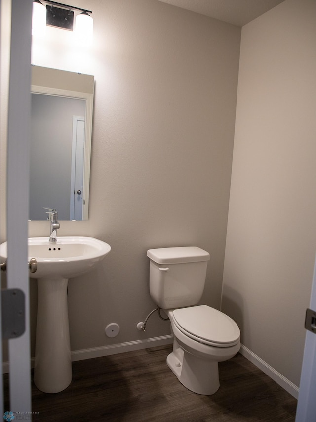 bathroom with hardwood / wood-style floors and toilet