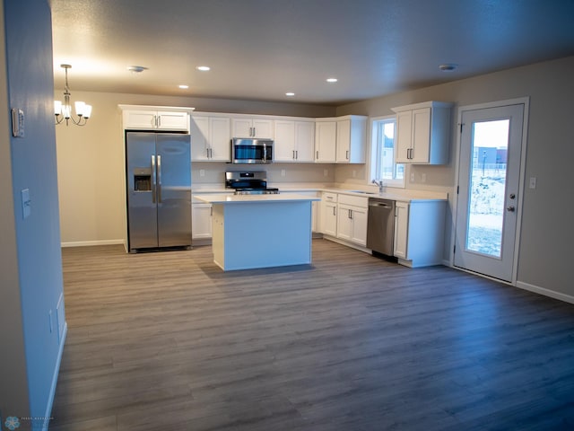 kitchen with sink, white cabinetry, decorative light fixtures, a center island, and stainless steel appliances