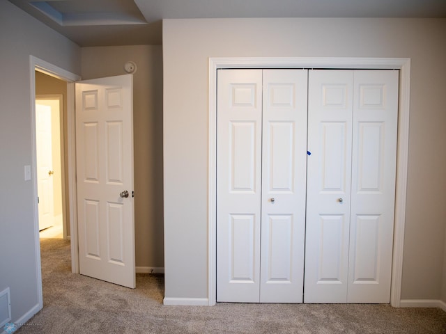 unfurnished bedroom featuring light carpet and a closet