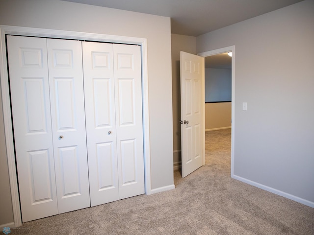 unfurnished bedroom featuring a closet and light carpet