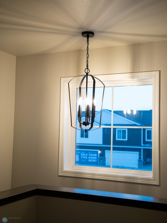 details with an inviting chandelier and a textured ceiling