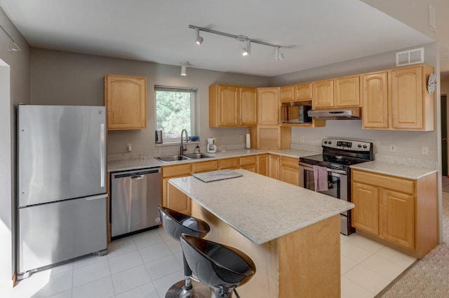 kitchen with a kitchen island, appliances with stainless steel finishes, sink, and light brown cabinets