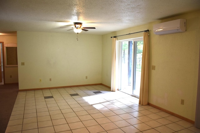 empty room with a textured ceiling, an AC wall unit, ceiling fan, and light tile patterned flooring