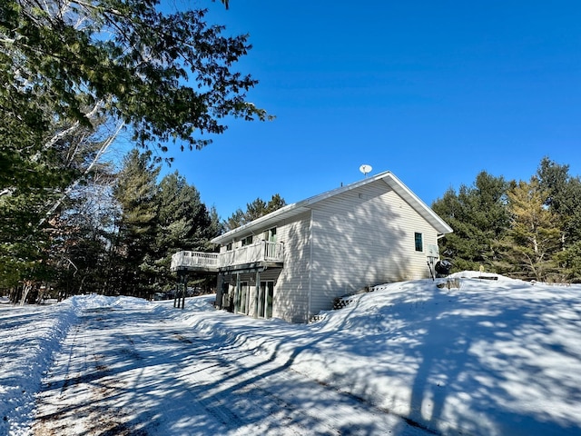 view of snow covered exterior featuring a wooden deck