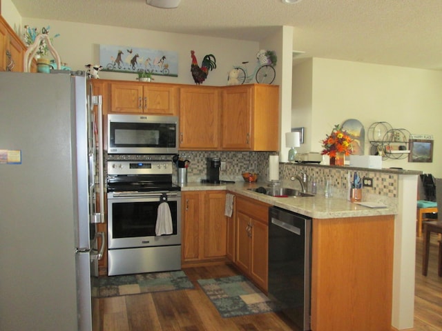 1902 Tiffany Cove Ln SW, Rochester, MN 55902 - kitchen featuring appliances with stainless steel finishes, a sink, dark wood finished floors, and a peninsula