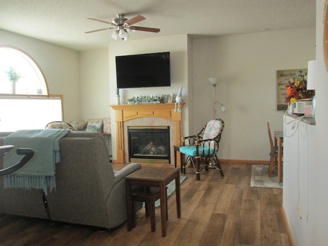 1902 Tiffany Cove Ln SW, Rochester, MN 55902 - living area with wood finished floors, a tiled fireplace, a ceiling fan, a textured ceiling, and baseboards