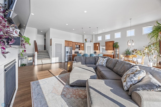 living room featuring dark hardwood / wood-style flooring, a chandelier, and a high ceiling