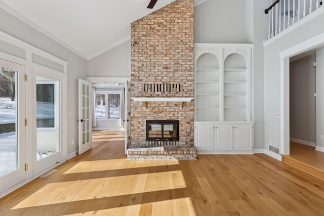 unfurnished living room featuring baseboards, a fireplace, high vaulted ceiling, and hardwood / wood-style floors