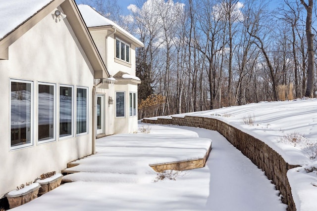 view of snowy exterior featuring stucco siding