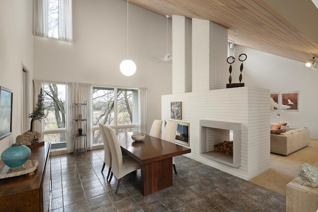dining space featuring plenty of natural light, high vaulted ceiling, french doors, and a fireplace