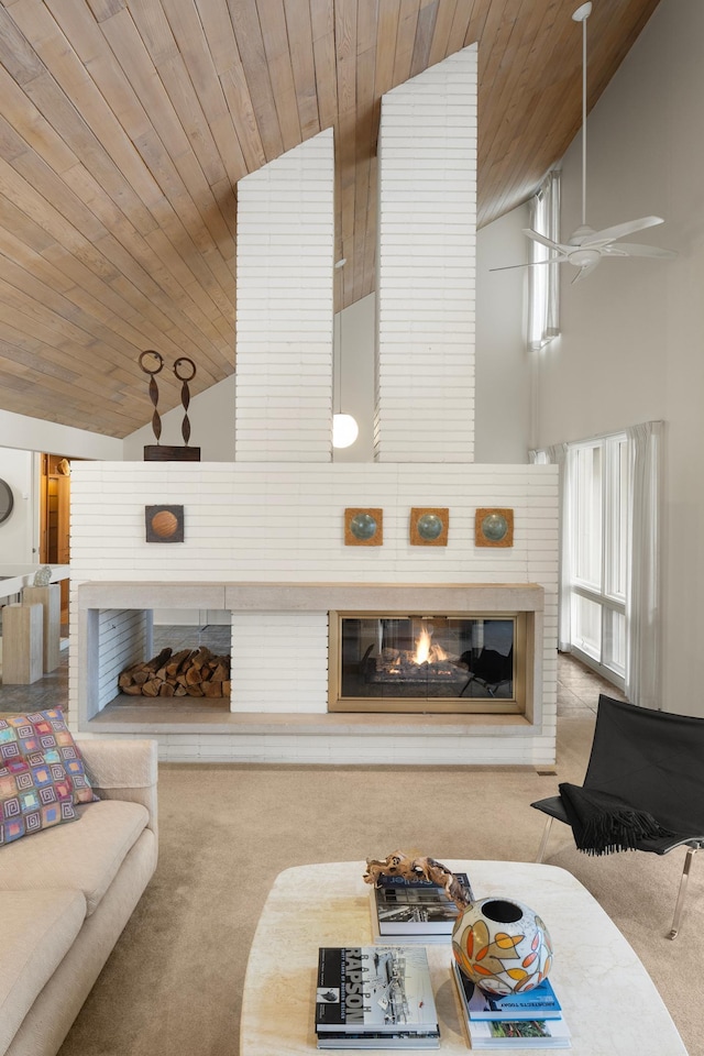 carpeted living room featuring a glass covered fireplace, a ceiling fan, high vaulted ceiling, and wood ceiling