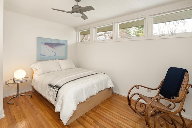 bedroom featuring baseboards, a ceiling fan, and light wood finished floors