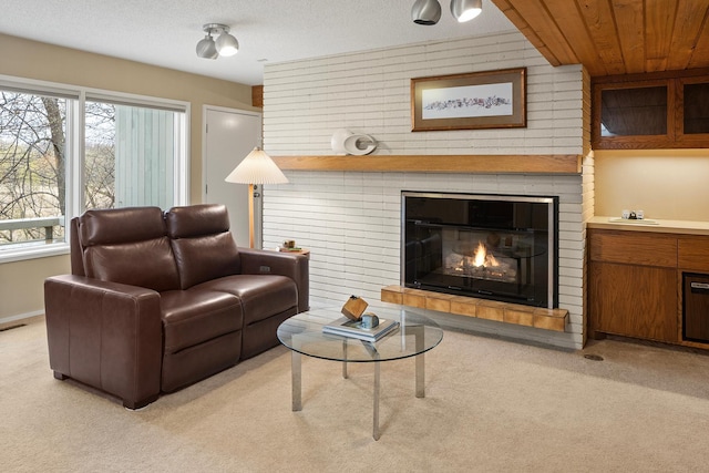 living area featuring visible vents, a fireplace, and light colored carpet